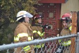 Lemoore Volunteer Rick Borba and fellow firemen Steve Young and John Paz keep an eye out for possible flareups Saturday at Lemoore house fire on Lum Court.